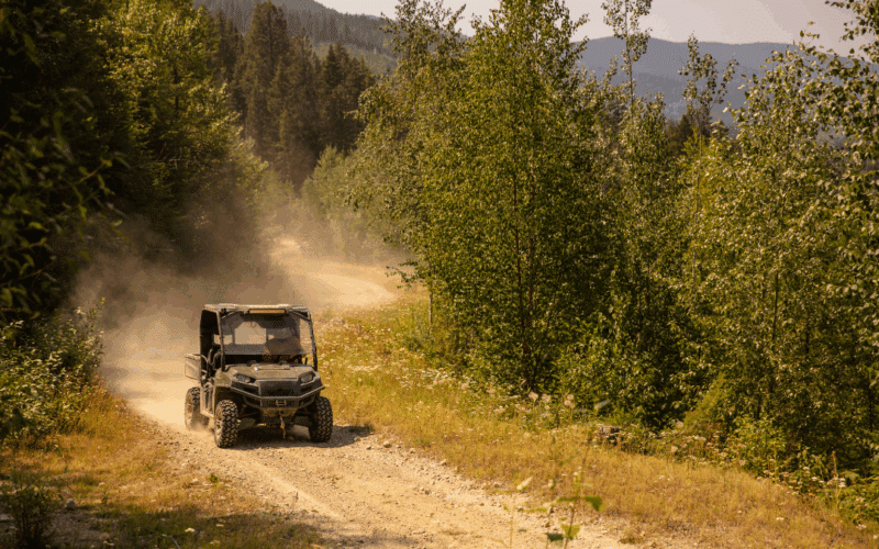 UTV with winch installed driving down a dirt road