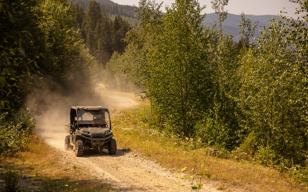 UTV with winch installed driving down a dirt road